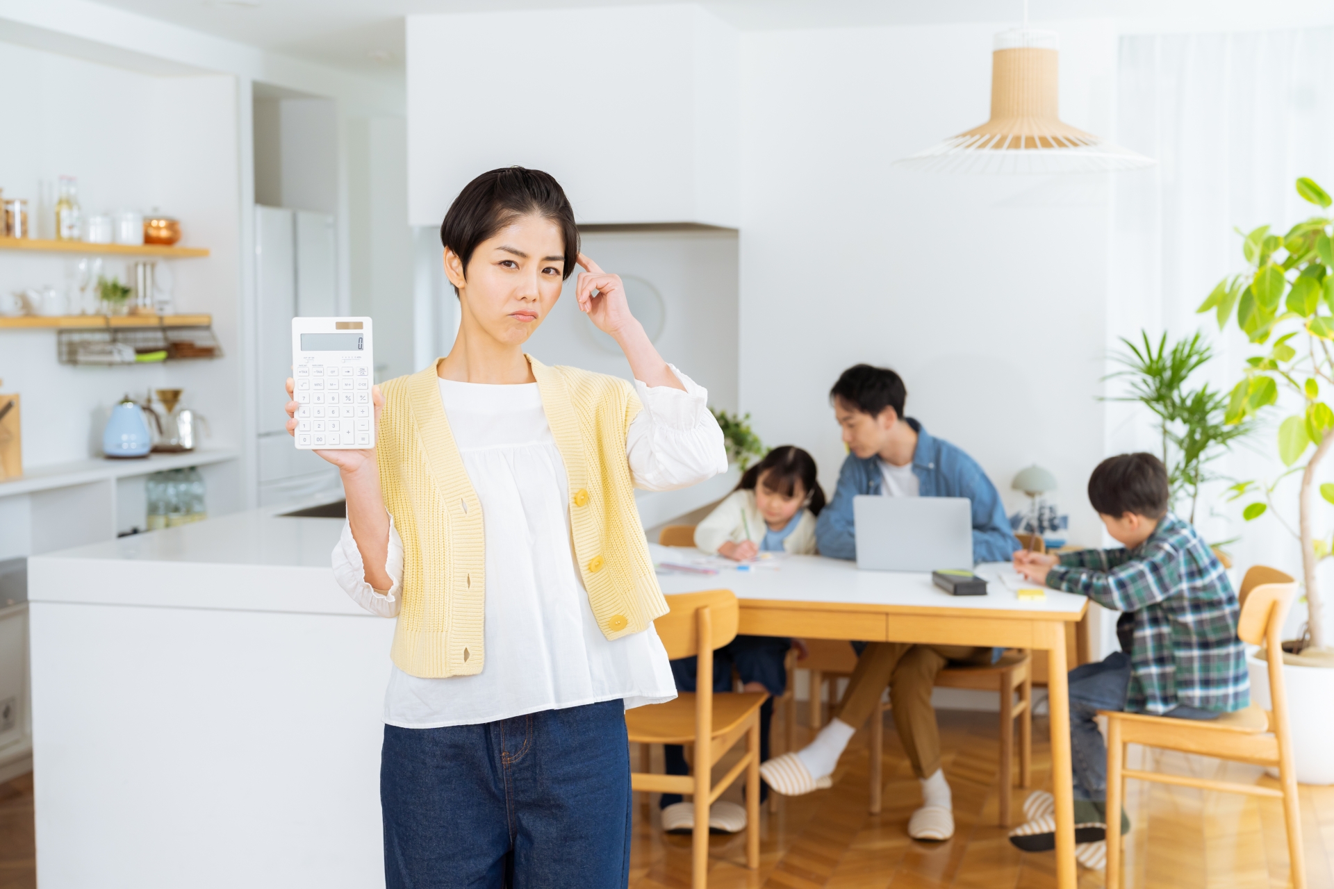 ダイニングルームで計算機を持つ主婦