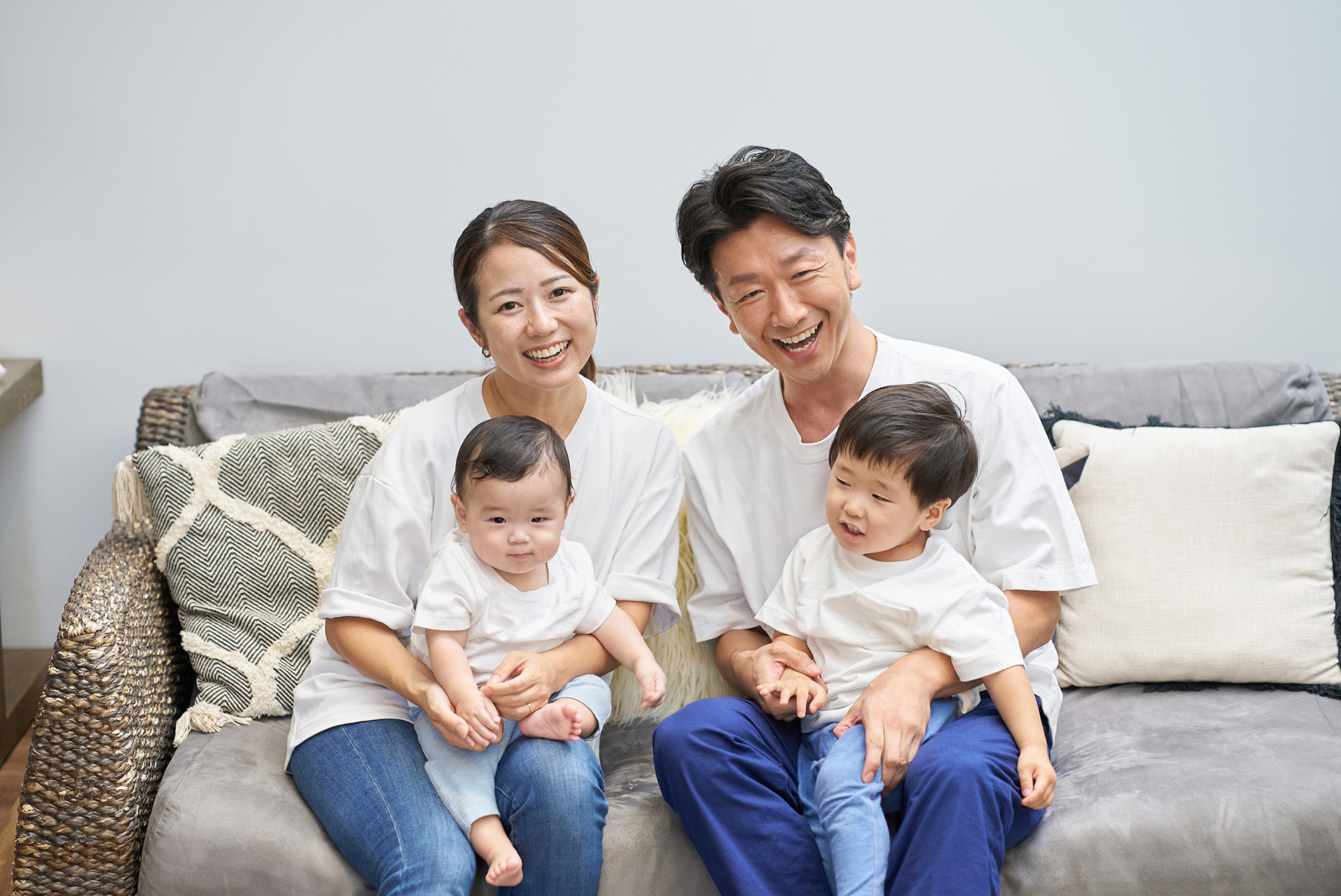 部屋のソファーでくつろぐ親子4人