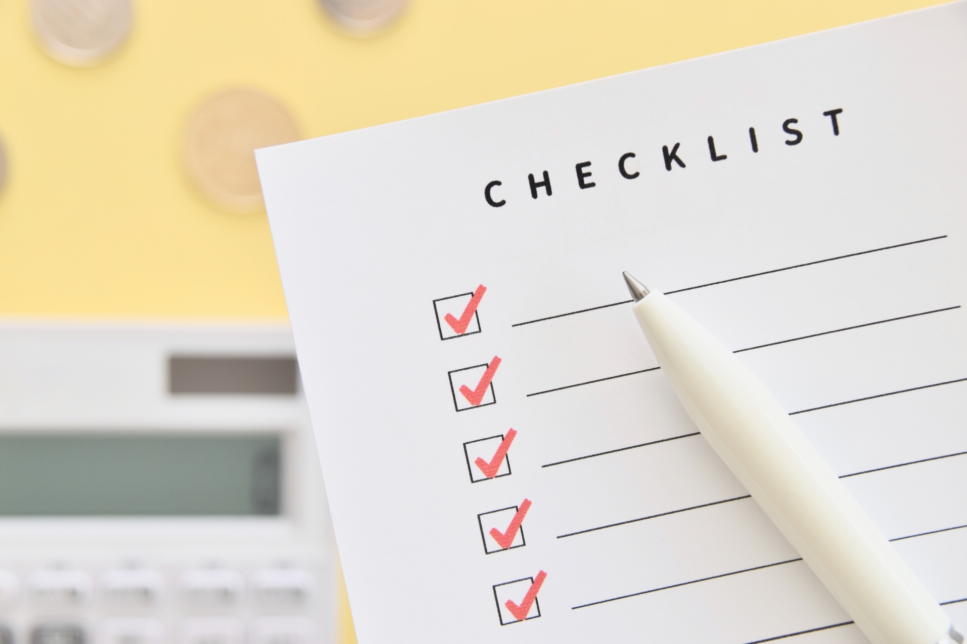 計算機と硬貨が背景のチェックリスト