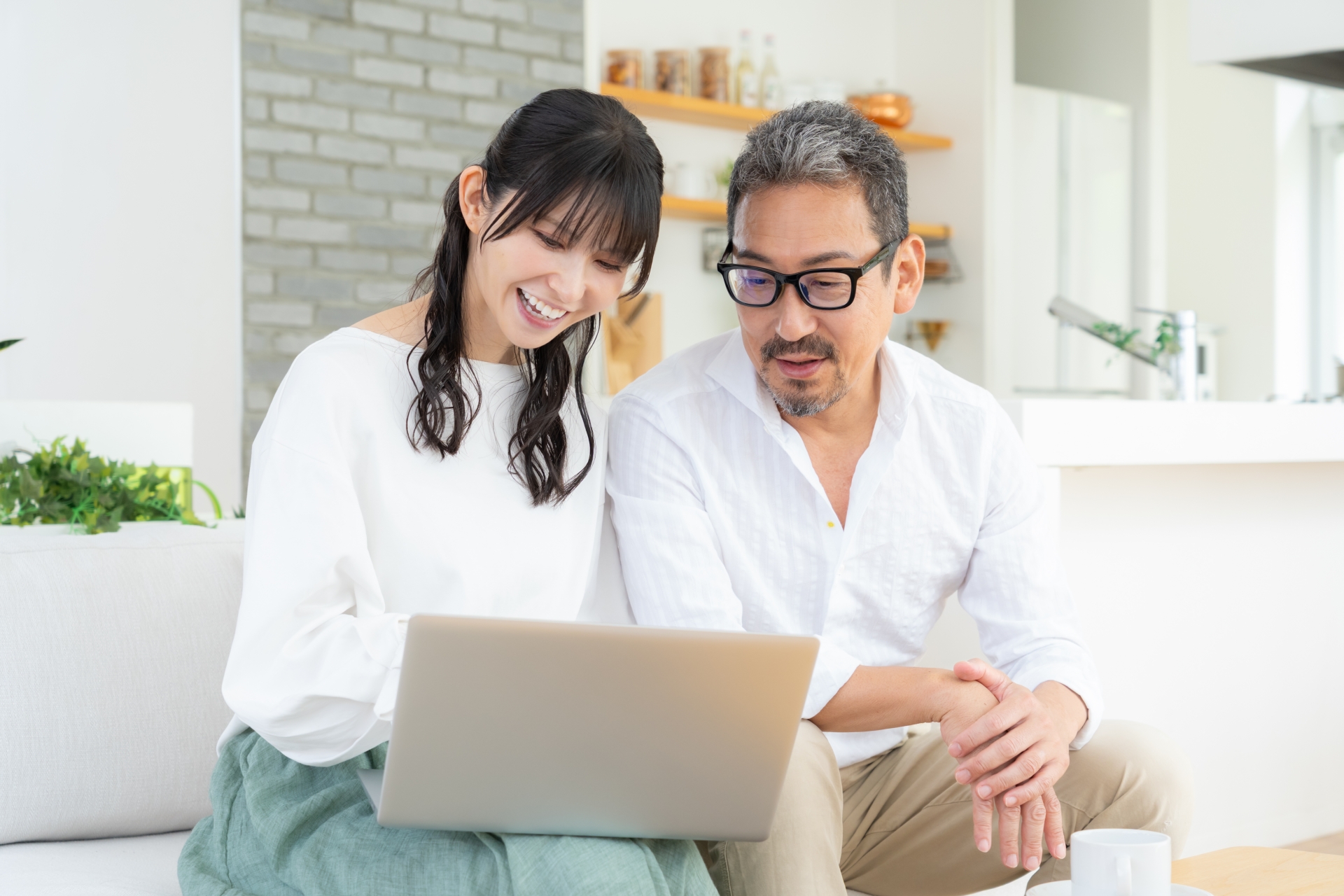 リビングでパソコンを見るミドルの夫婦