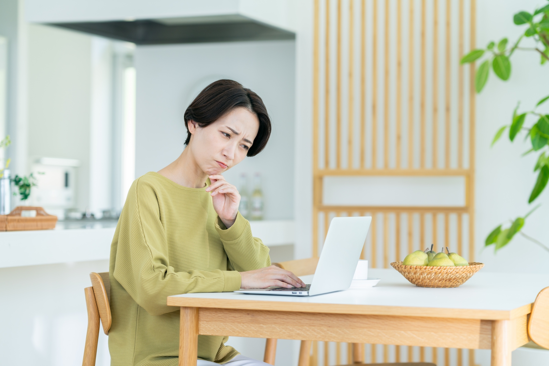 パソコンを見て悩む女性