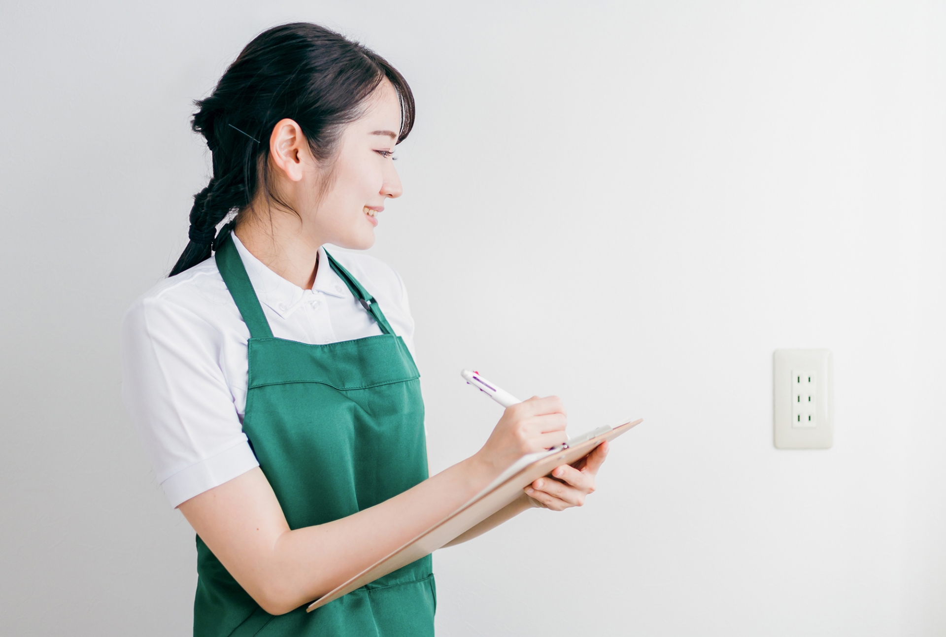 電源プラグの差し込み口を点検する女性