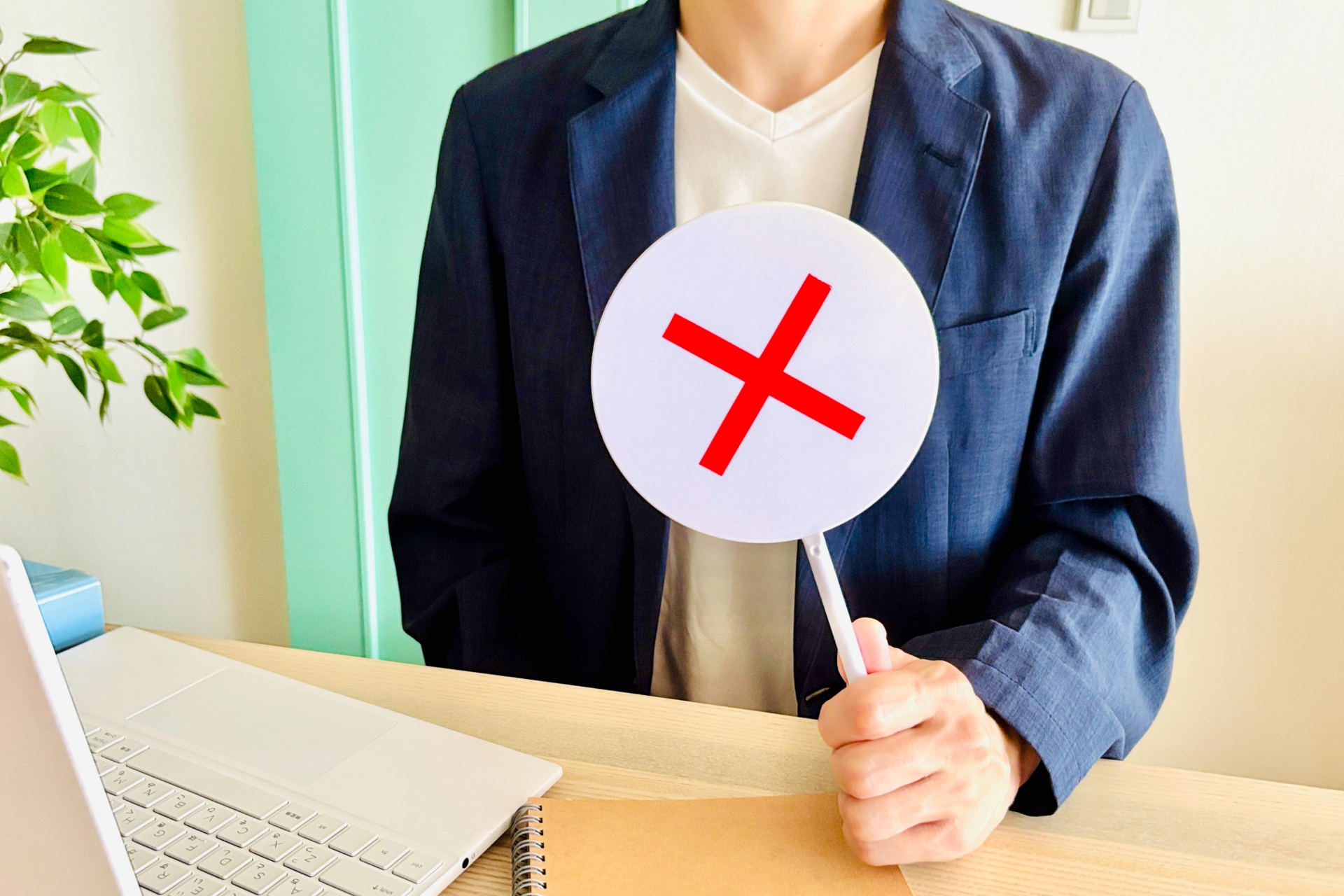 バツマークを持つ男性