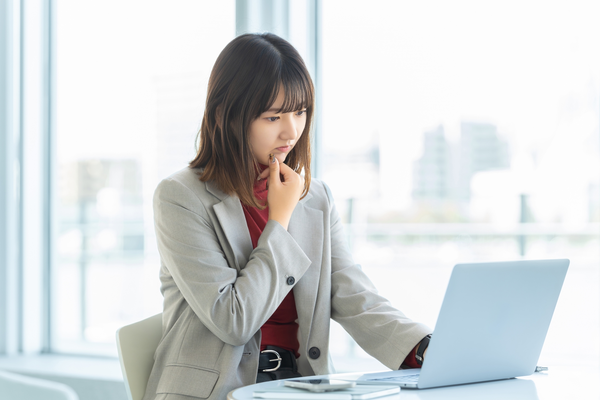 パソコンを見て悩む女性