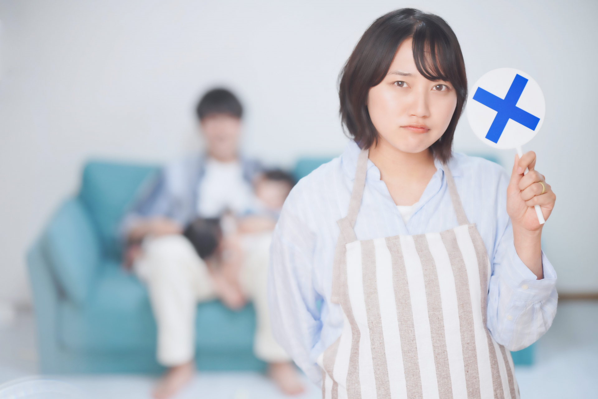 バツマークを持つ女性