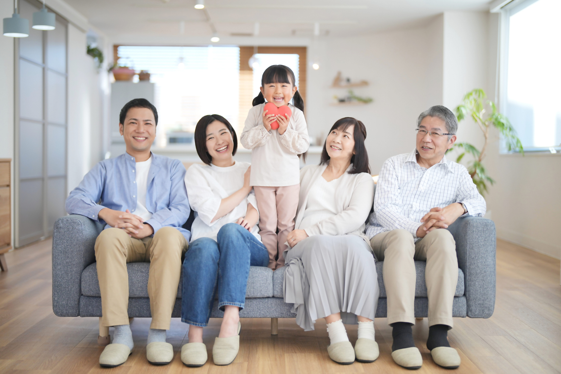 ソファーに座る家族と間で立っている女の子