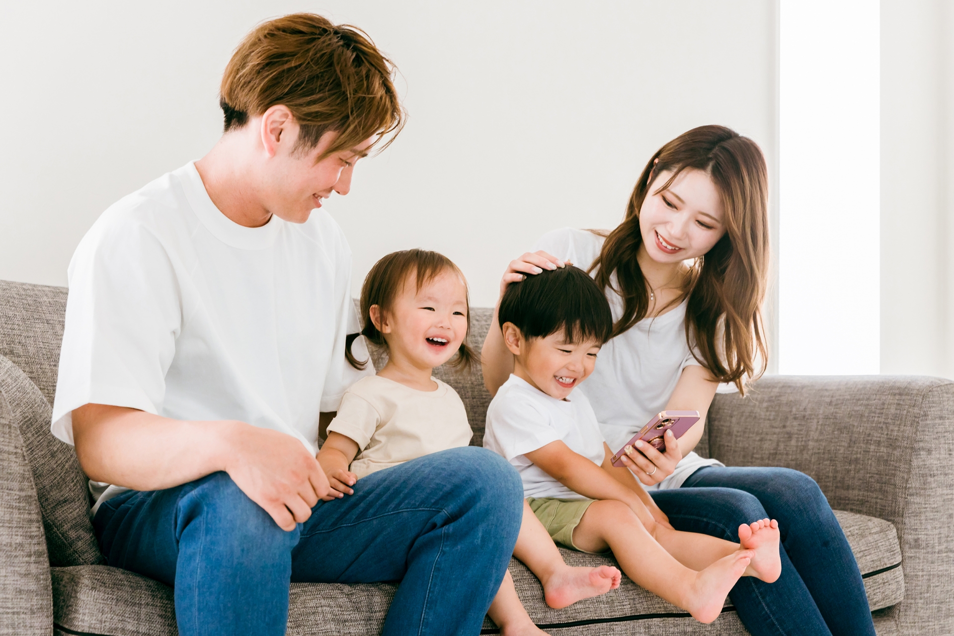 リビングでスマホを見る日本人家族(親子)