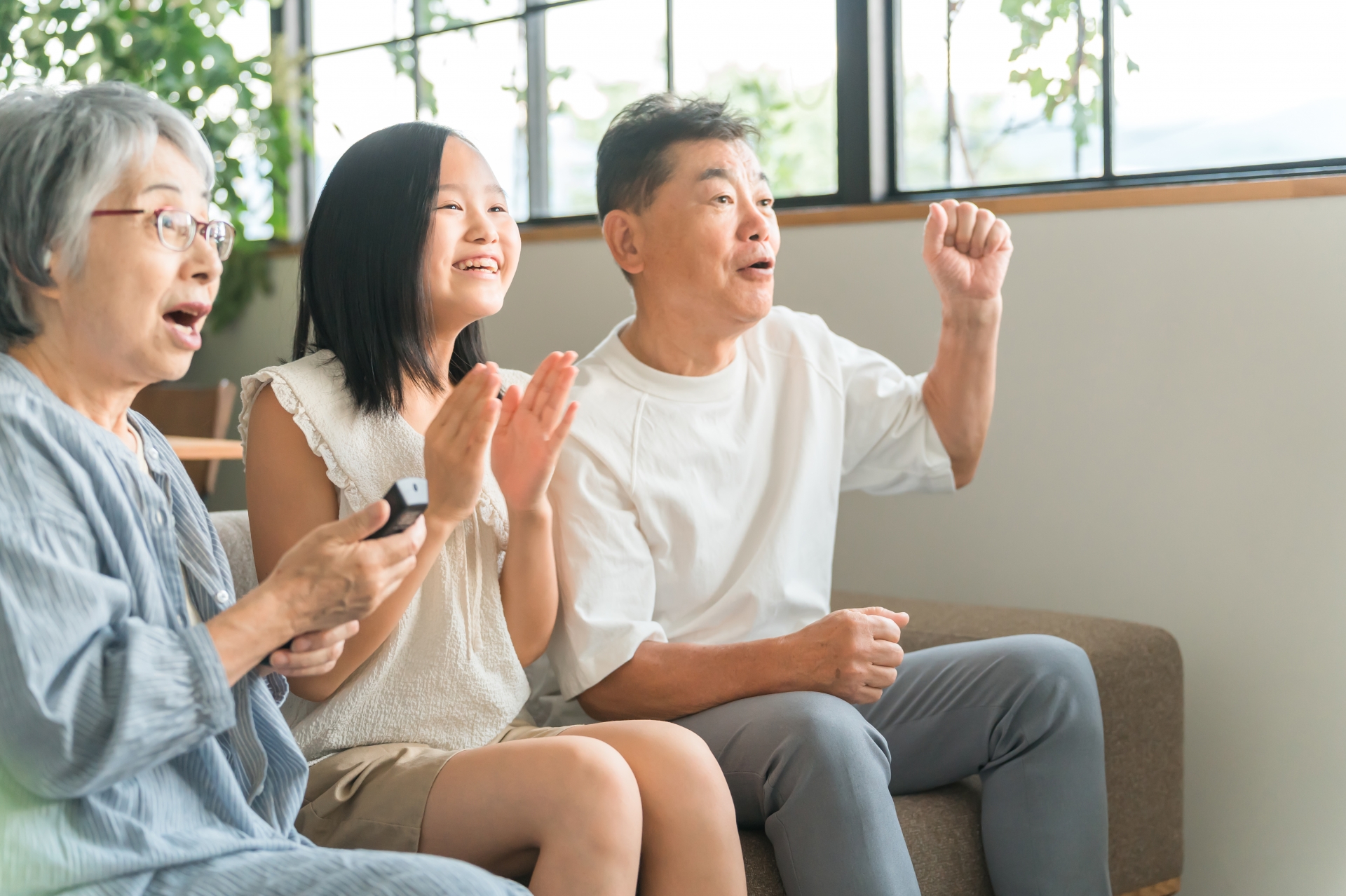 テレビを見ながら盛り上がる祖父母と孫