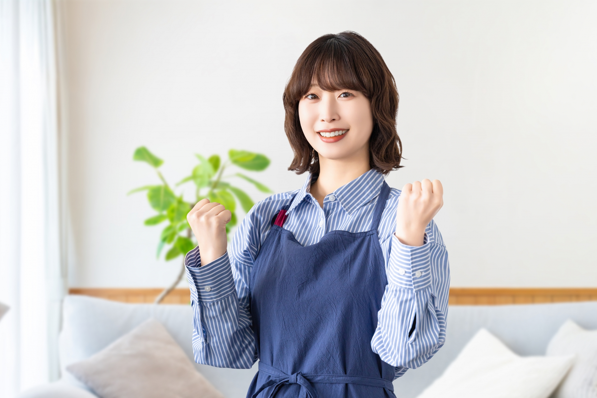 ガッツポーズをするエプロン姿の女性