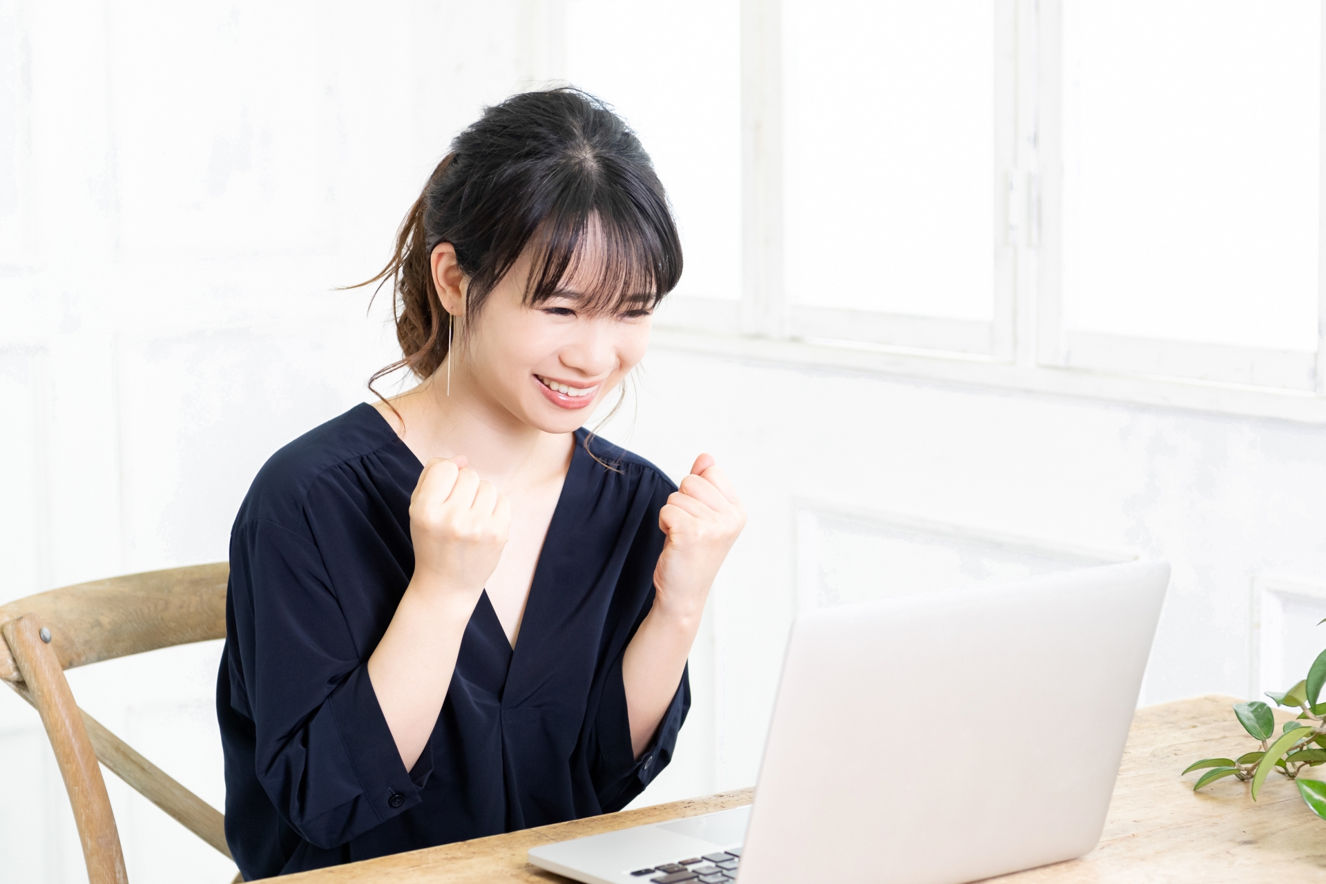 ガッツポーズをする若い女性