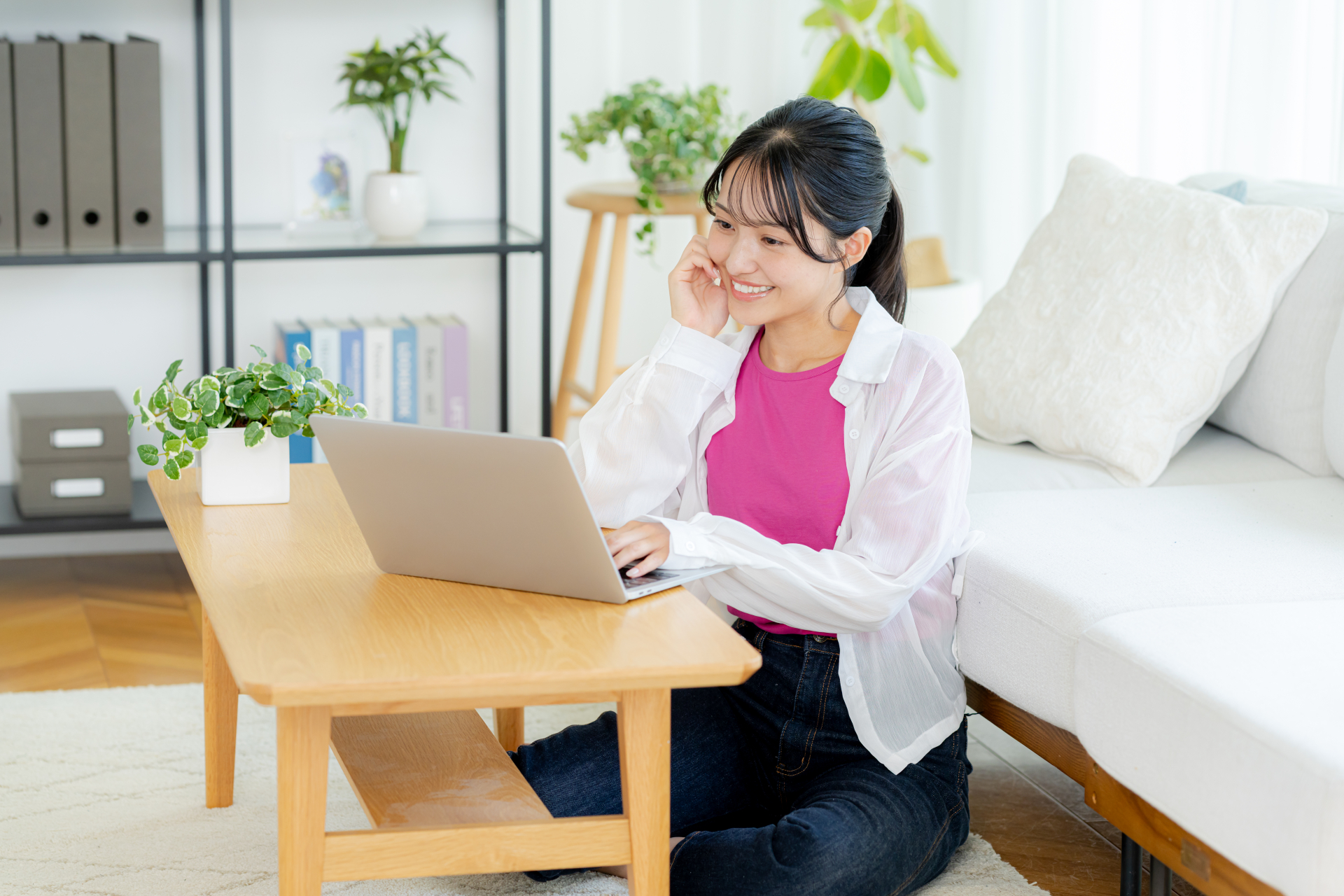 自宅でノートパソコンを操作する若い女性
