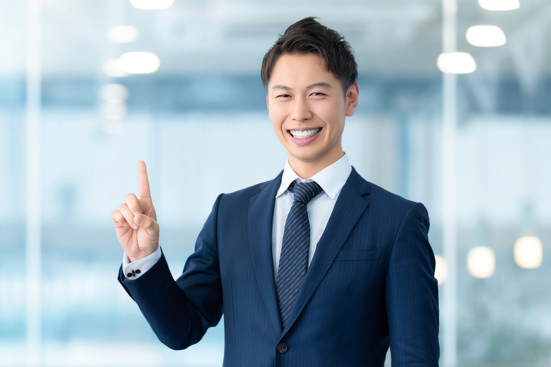 人差し指を立てて案内する男性ビジネスマン