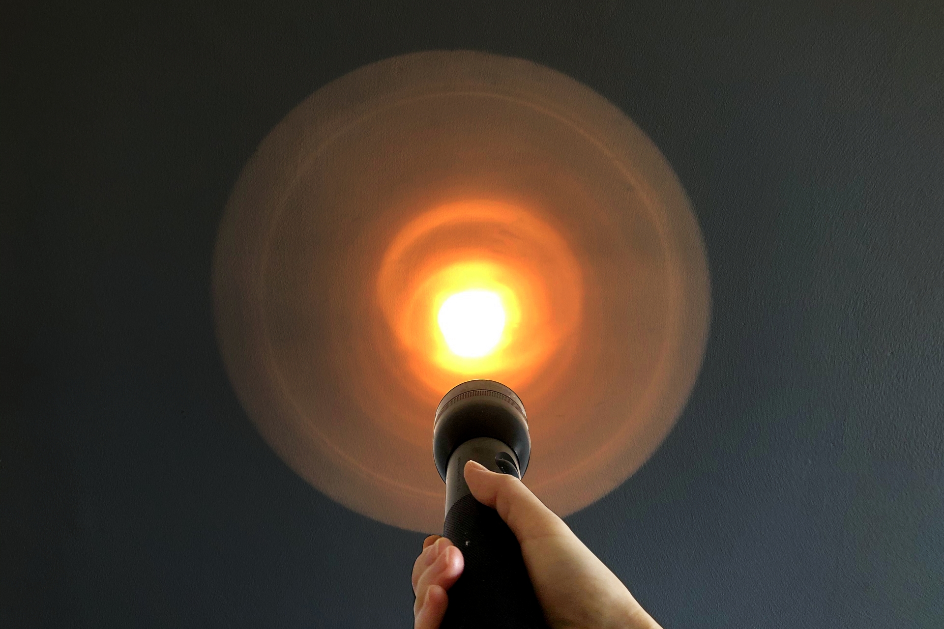 懐中電灯で壁を照らす