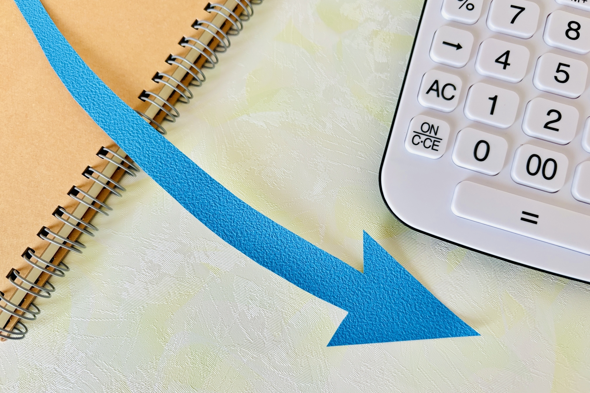 下がる矢印と電卓・急降下する