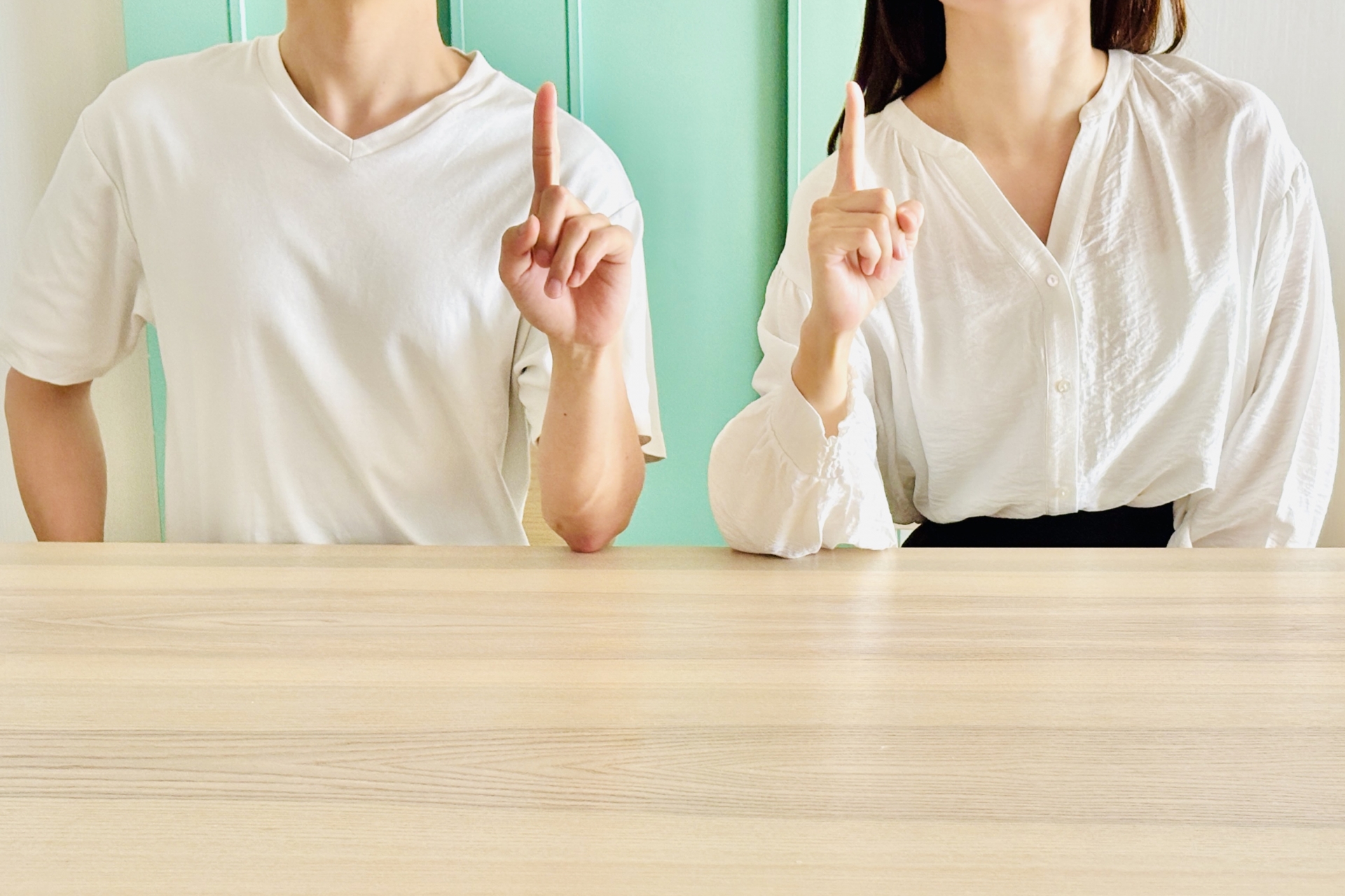 指でポイントを示す男女