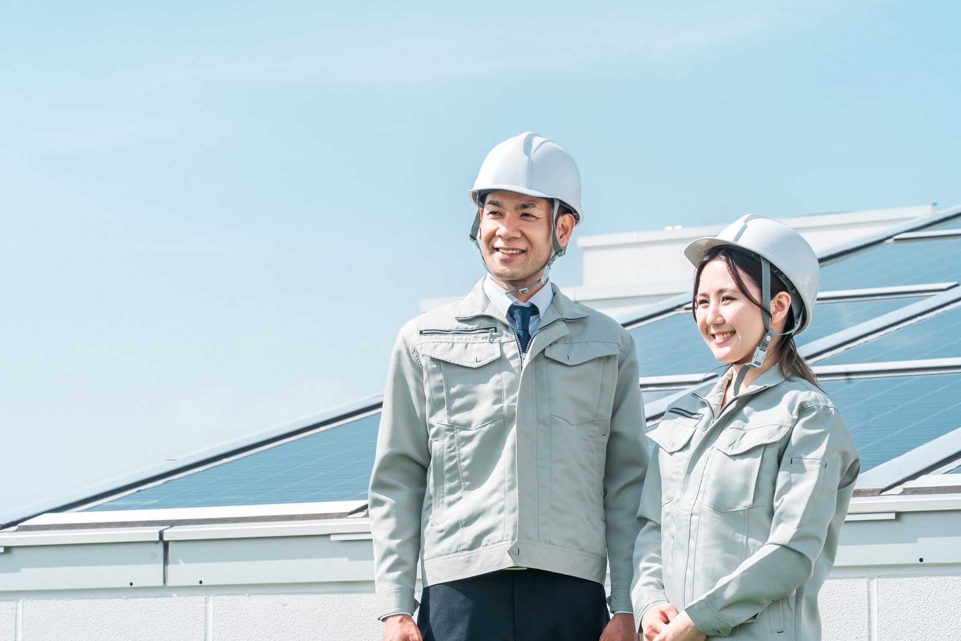 ソーラーパネルの前に立つ電力会社の技術者