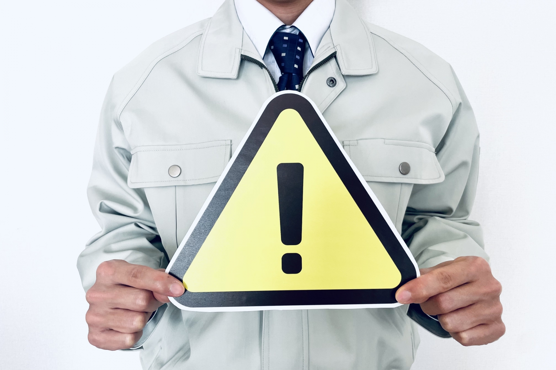 注意マークを持つ男性作業員スタッフ