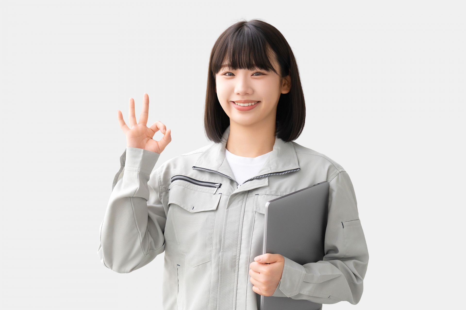OKポーズをする作業服を着た若い女性