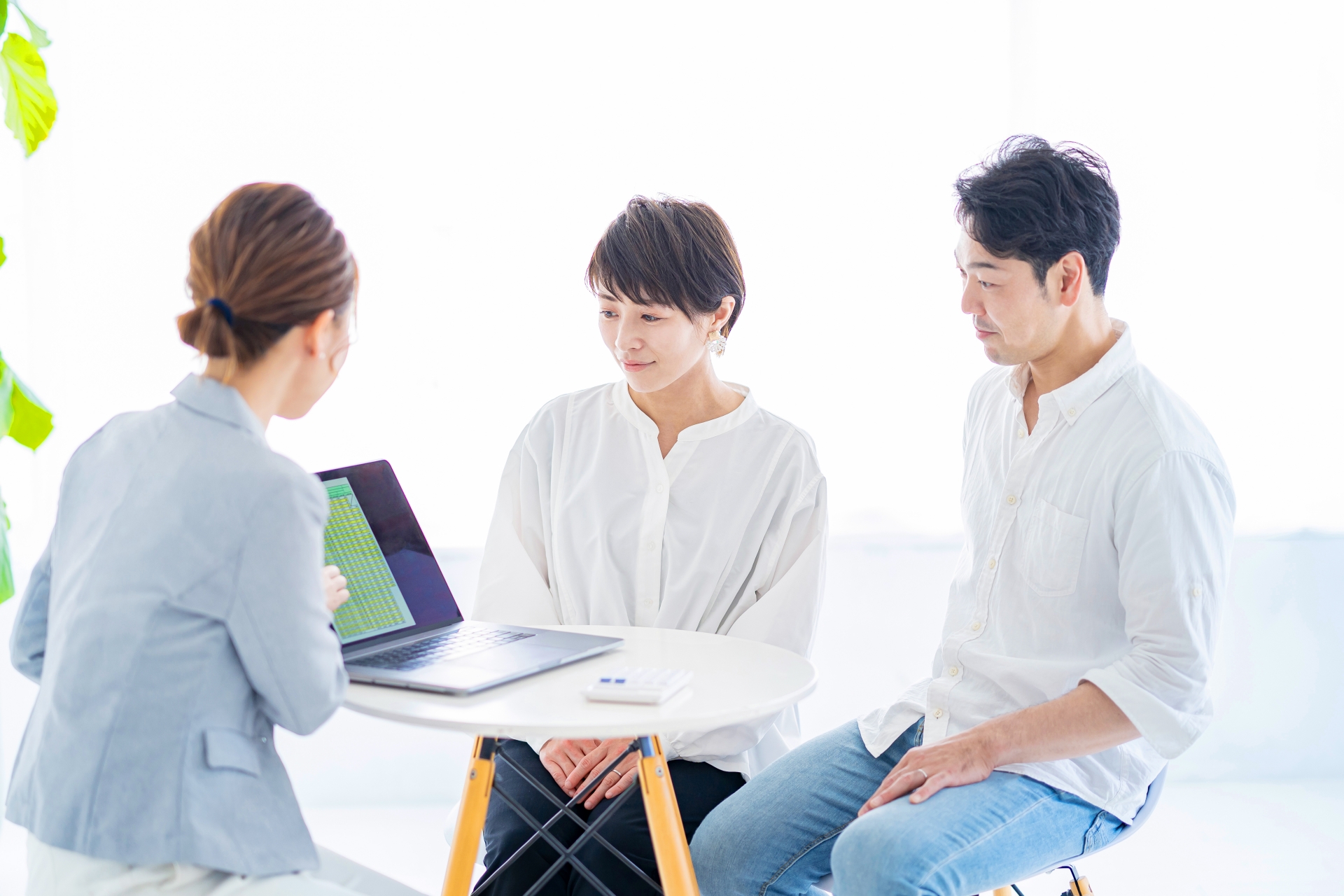 スーツ姿の女性から説明を受ける夫婦