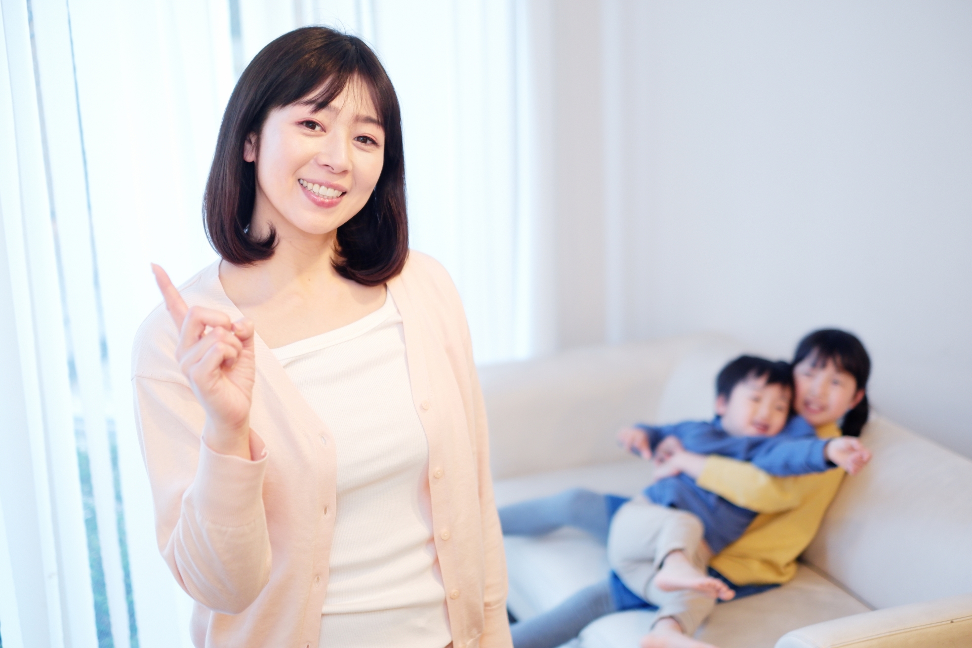 人差し指を立てている主婦