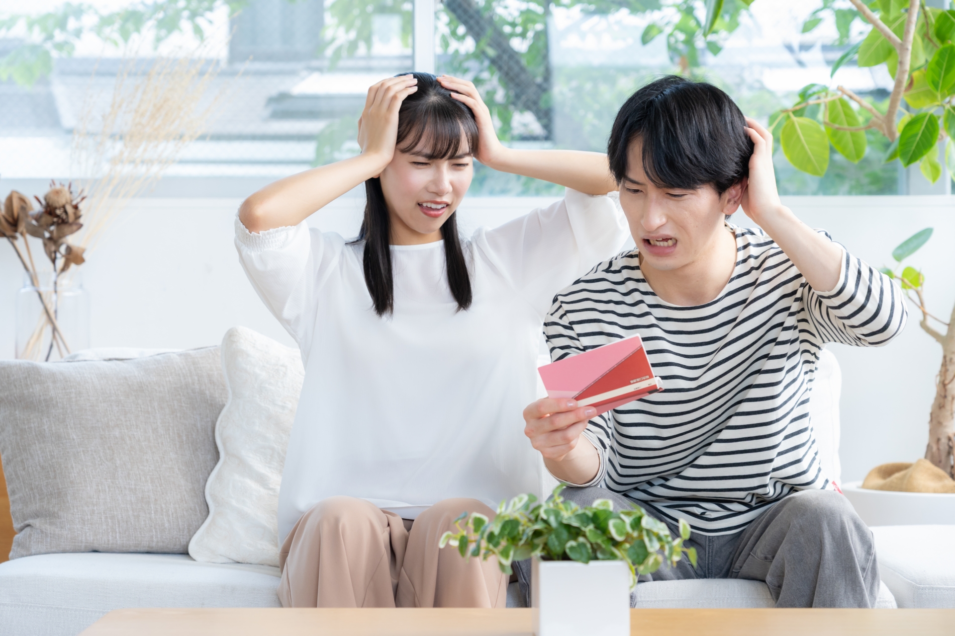 通帳を見て頭を抱える夫婦