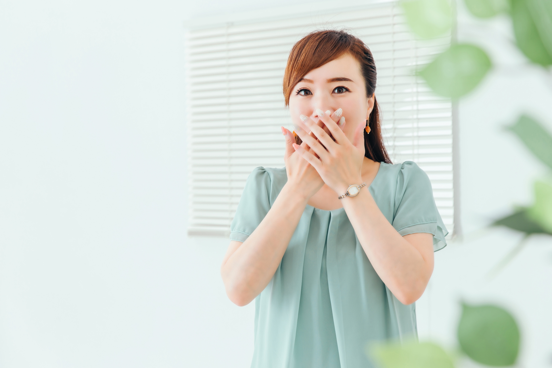 口を押える女性