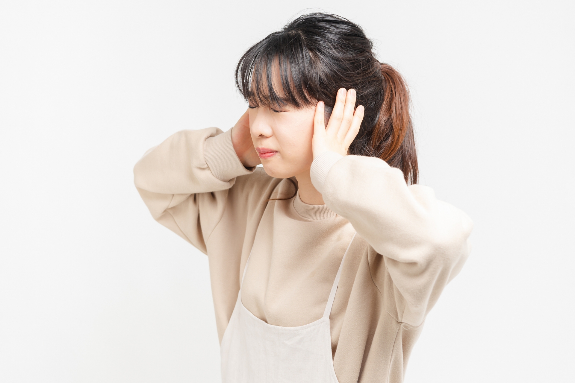 耳をふさぐ女性