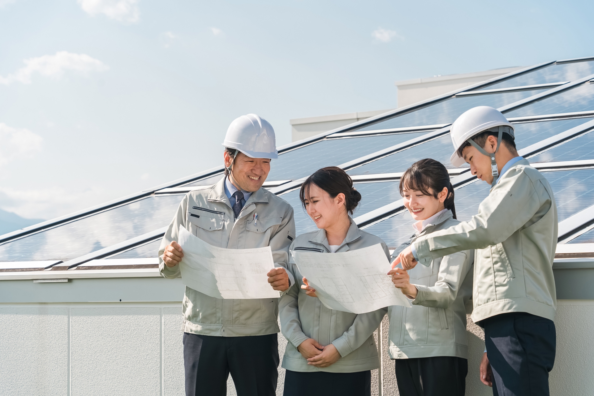 太陽光発電の前に立つ電気工事業者の技術者