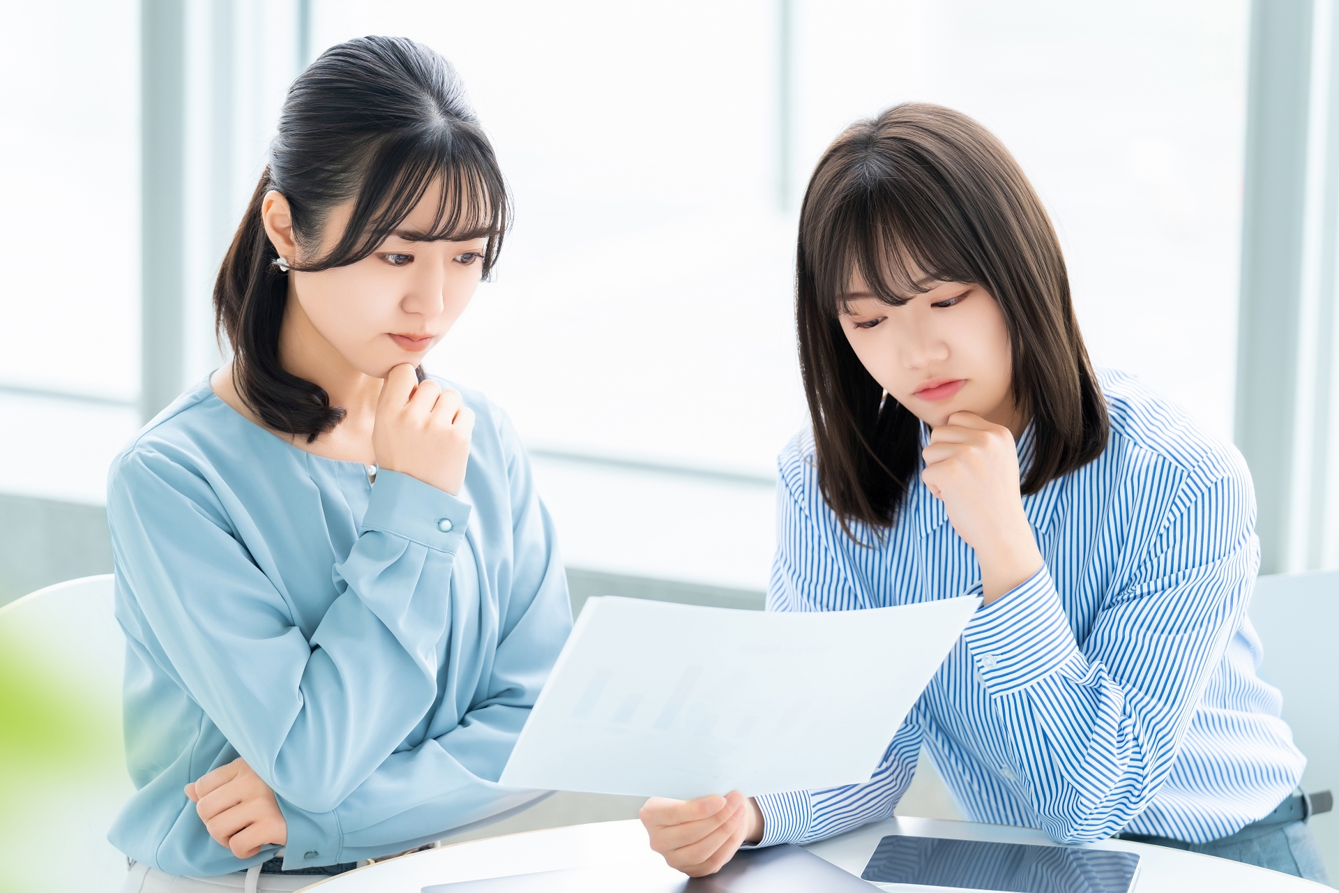 資料を見て悩む女性