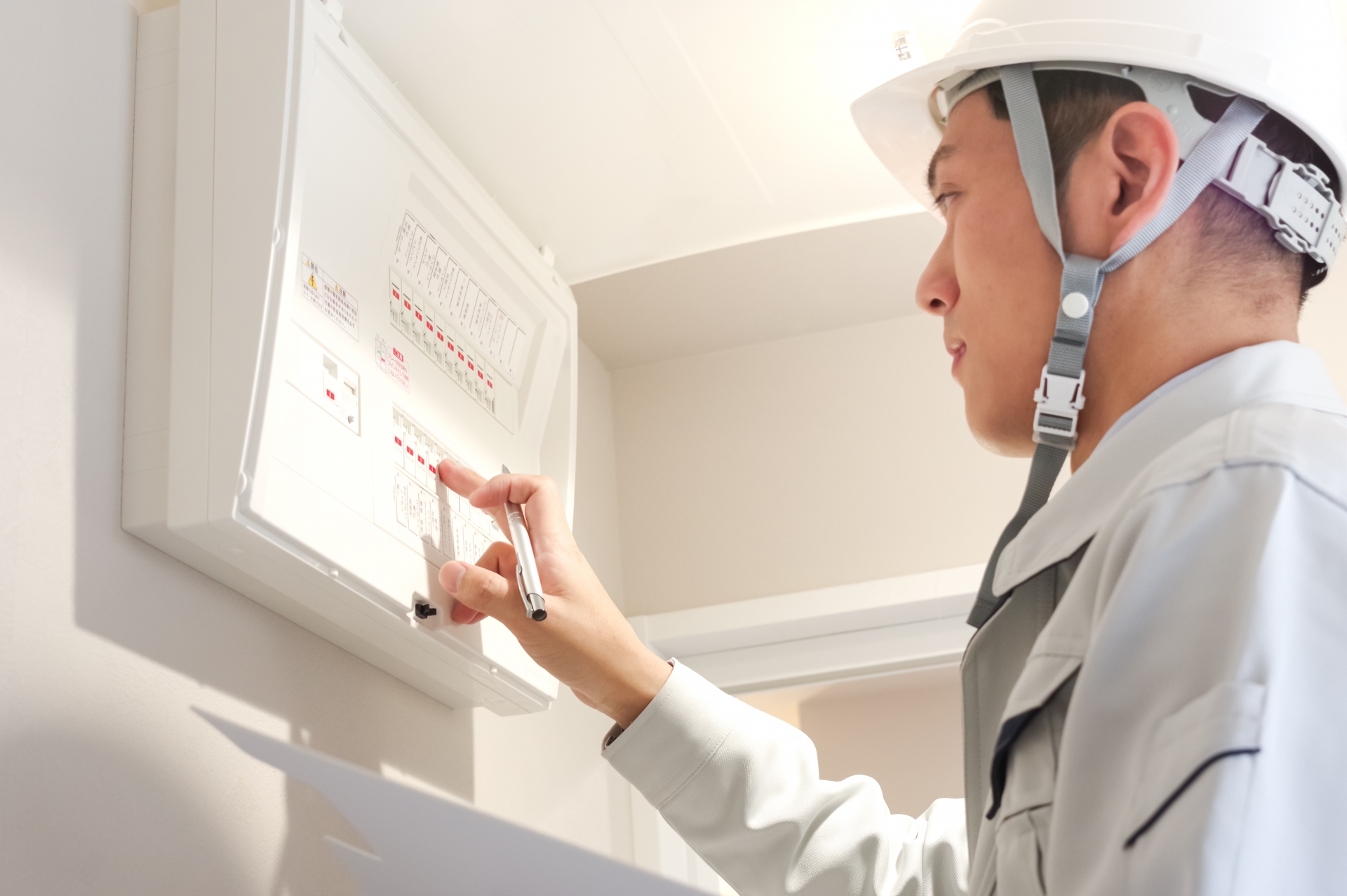配電盤の検査をする作業服の男性