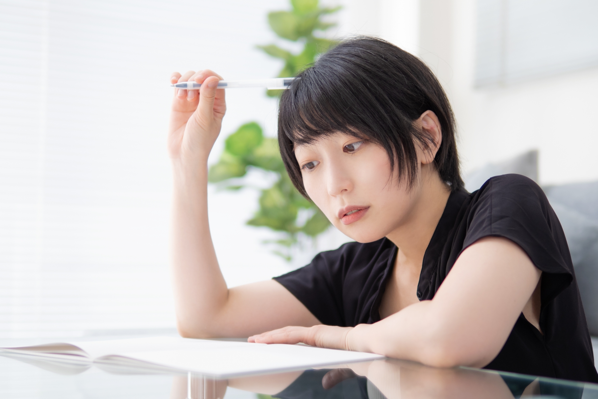 ノートを見ながら考える女性