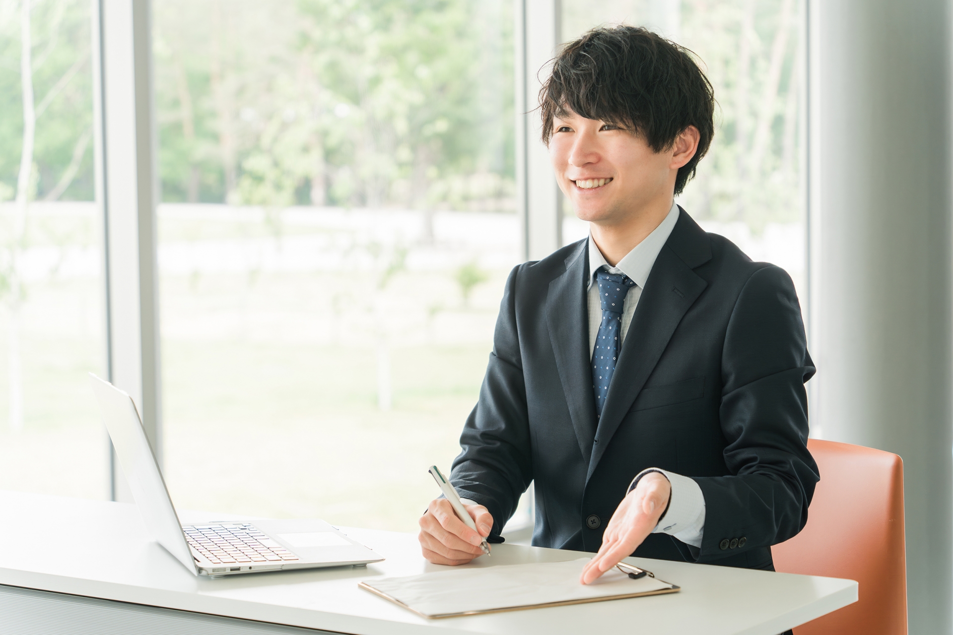 書類を使い案内する若い男性ビジネスマン