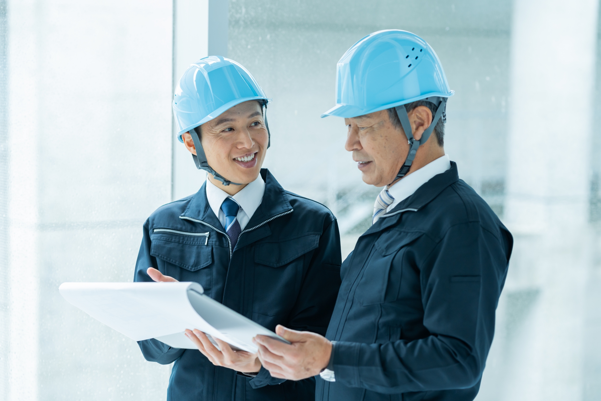 用紙を見ながら確認しあう男性2人