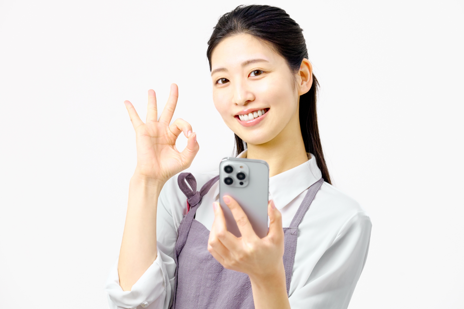 スマホを持ちOKサインを出す女性