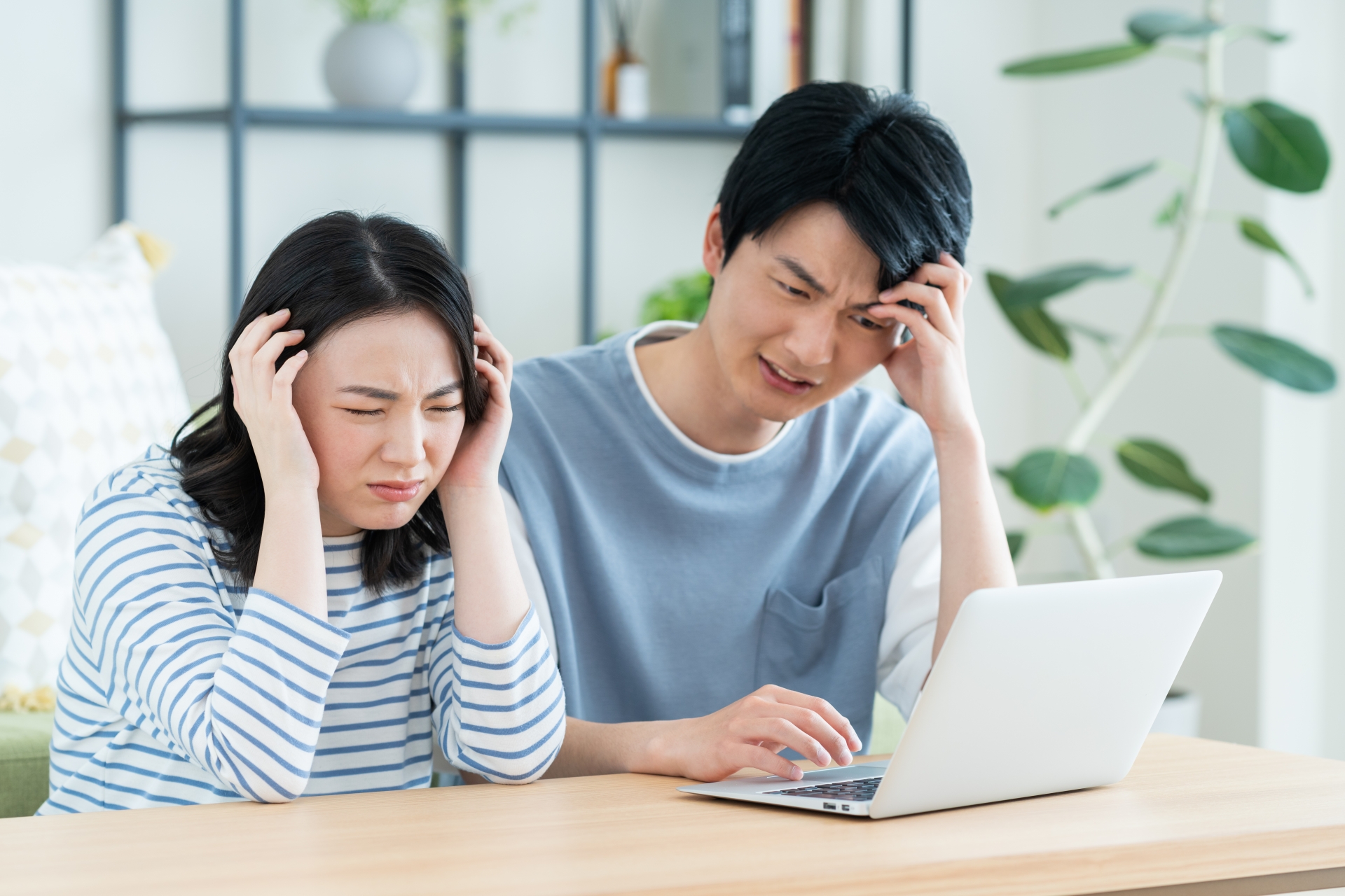 パソコンで悩む若い夫婦